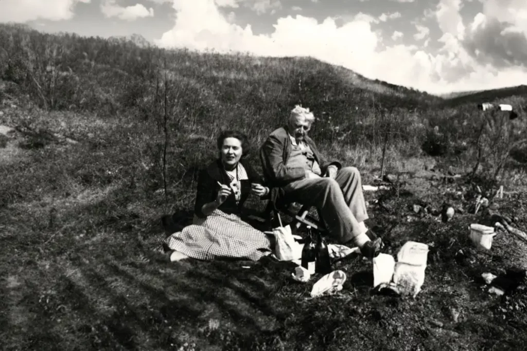 Ralph and Ursula Vaughan Williams sit on a hill having a picnic