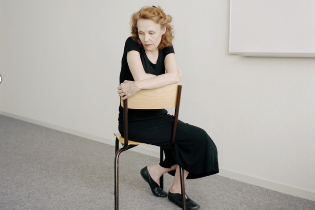 Kaija Saariaho seated in a chair, looking off to the side.
