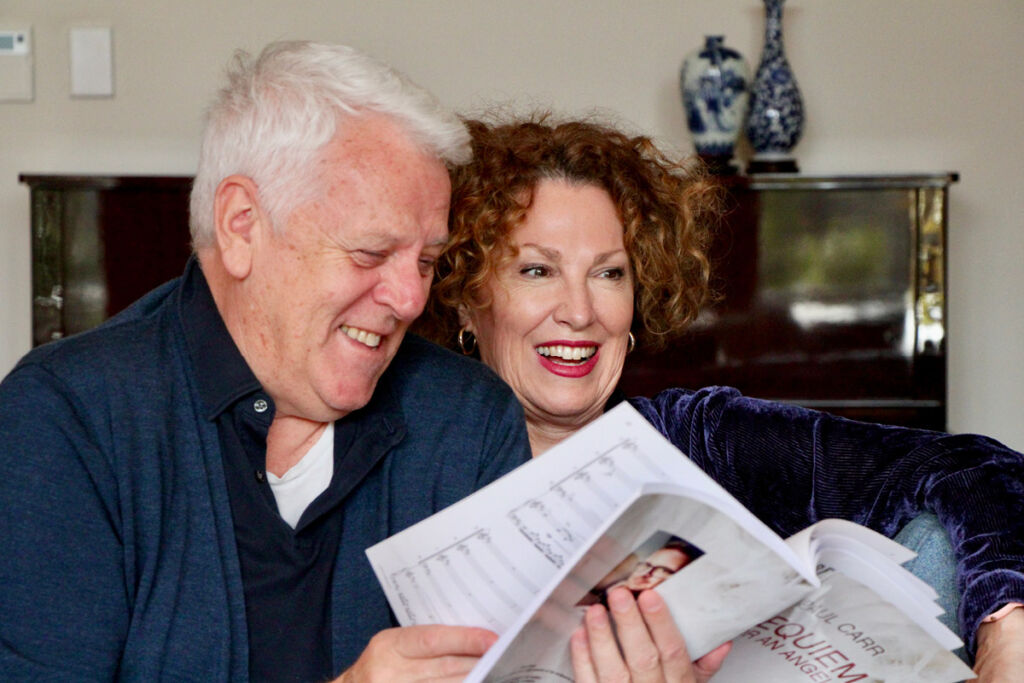Peter Coleman-Wright and Cheryl Barker flip through a score, smiling.