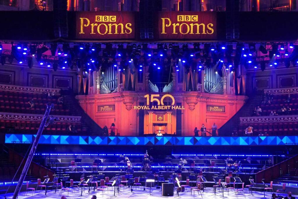 An empty stage at the Royal Albert Hall, with BBC Proms banners hanging above in gold.
