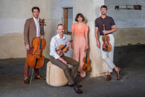 The Australian String Quartet pose in a sandstone doorway.