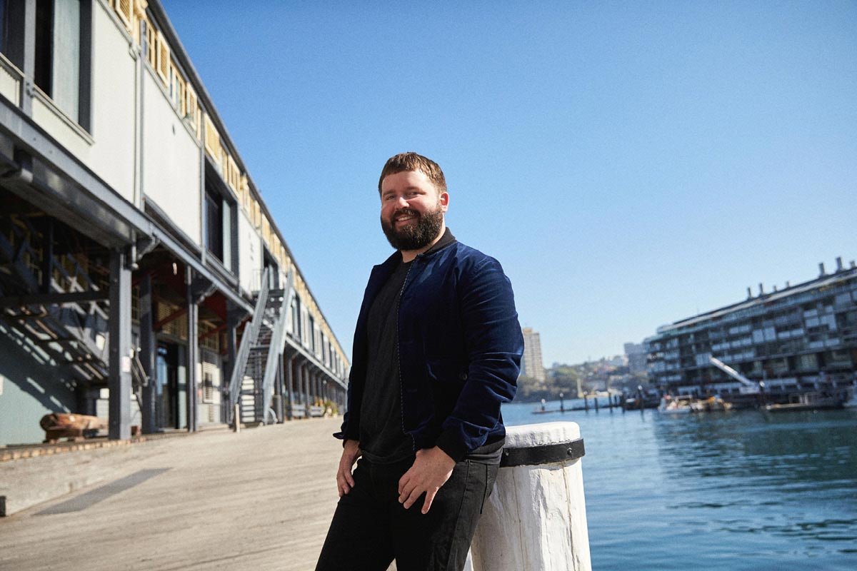 Kip Williams stands on a pier in Walsh Bay, Sydney.