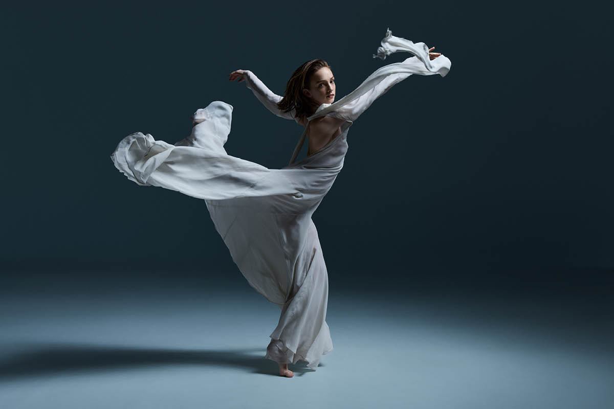 Samara Merrick, wearing a flowing white outfit, strikes a pose.