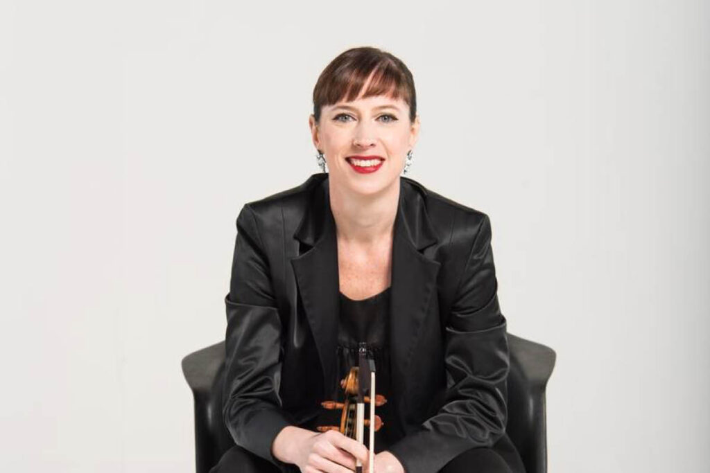 Madeleine Easton, Australian World Orchestra concertmaster, holding her violin.