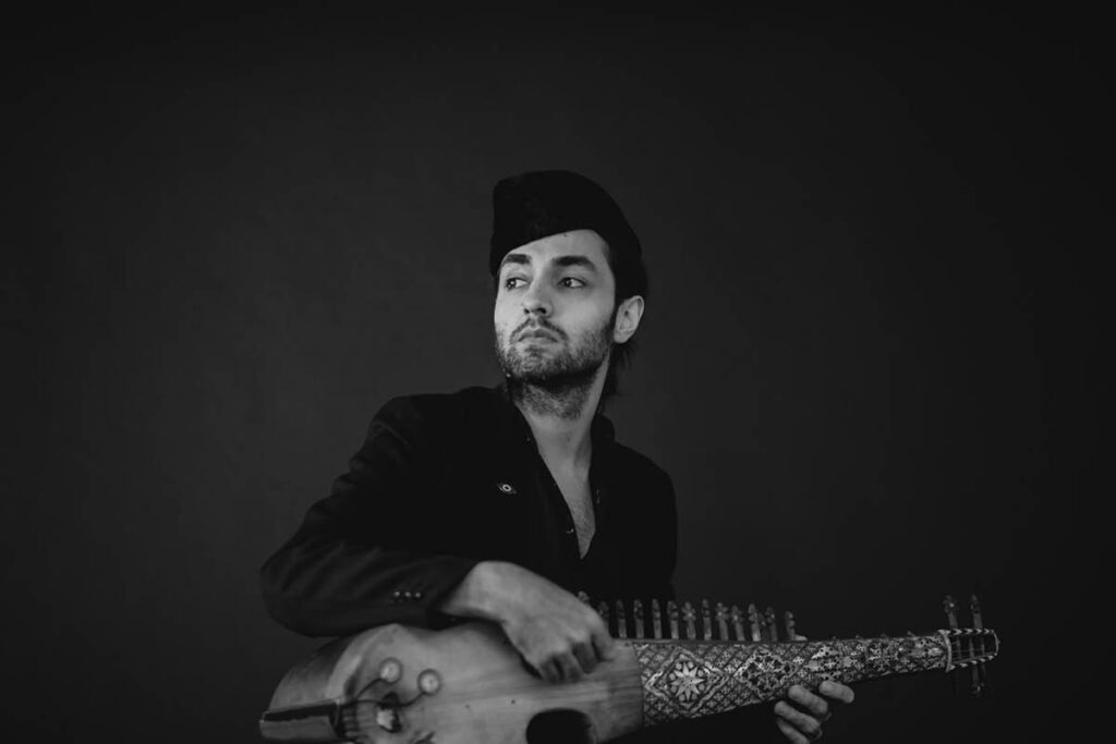 Qais Essar holding the rabab.