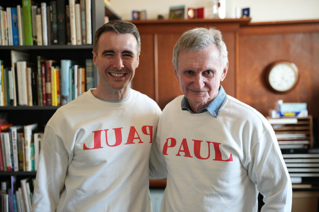 Paul Hodge and Paul Jennings. Jennings wears a shirt that says 'Paul', and Hodge wears a shirt that has 'Paul' mirrored.