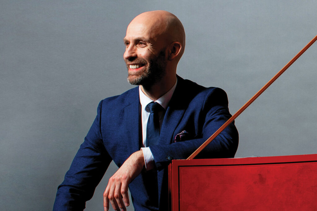 Erin Helyard sitting at a harpsichord.