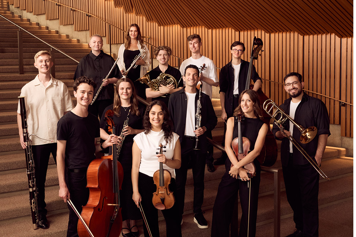 2025 Sydney Symphony Orchestra Fellows, standing on the stairs at the Sydney Opera House.