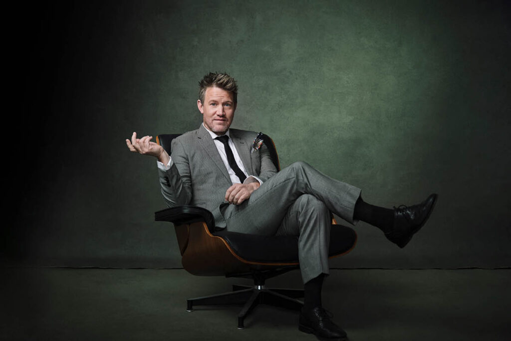 Eddie Perfect, creator of Beetlejuice the Musical, sits in an armchair.